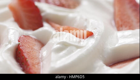 Fresco affettato straberries in background di crema Foto Stock