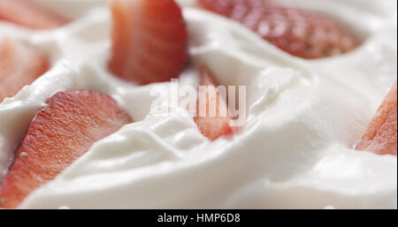 Fresco affettato straberries in background di crema Foto Stock