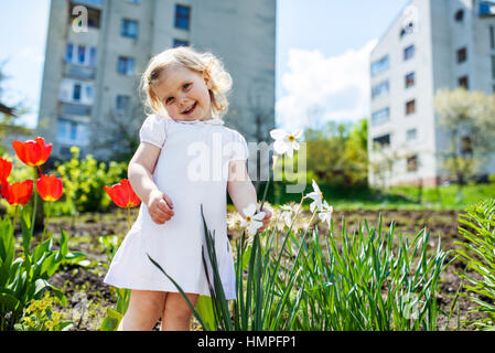 Bambino a fiore in giardino Foto Stock