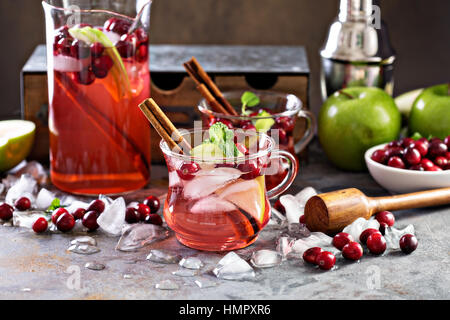 Inverno rinfrescante cocktail con ghiaccio, mele e cranberry in bicchieri di vetro Foto Stock