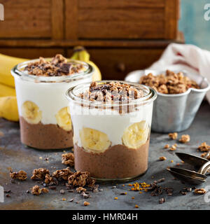 Cioccolato budino di chia parfait con banana, muesli e yogurt Foto Stock