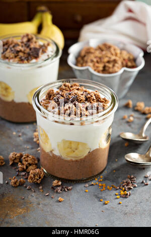 Cioccolato budino di chia parfait con banana, muesli e yogurt Foto Stock