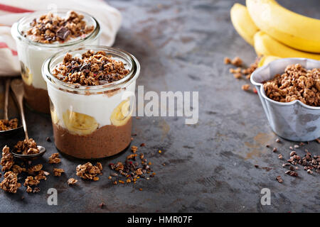 Cioccolato budino di chia parfait con banana, muesli e yogurt Foto Stock