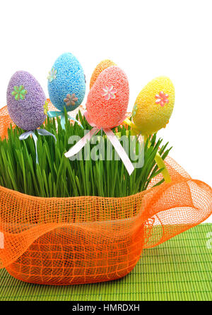 Colorate le uova di pasqua in montagna con aiuola verde erba fresca isolato su bianco Foto Stock