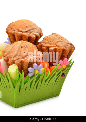 Deliziosi muffin, caramelle colorate nel cestello verde isolato su bianco Foto Stock