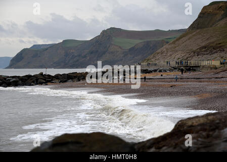 Regno Unito. West Bay,Dorset, Regno Unito. 5 febbraio 2017. Regno Unito Meteo. In seguito al recente il mare in tempesta, i visitatori di camminare sulla spiaggia occidentale con il famoso Jurrassic costa in background su un ventoso e grigio domenica pomeriggio. Credito: Giovanni Gurd Media/Alamy Live News Foto Stock