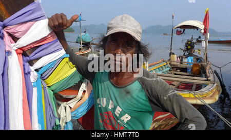 Pescatore in piedi dal suo longtail boat, Koh Jum, Thailandia Foto Stock