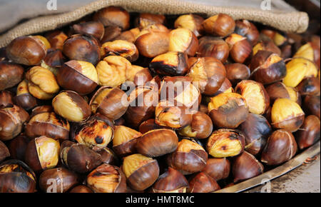 Castagne cotte in vendita in stallo in strada Foto Stock