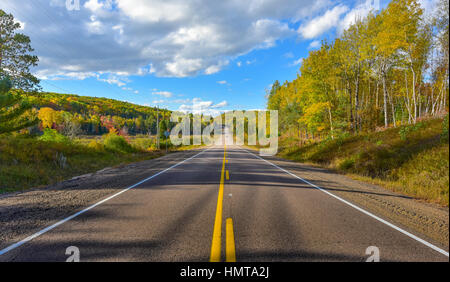 Sunny road per ovunque e il punto singolo di prospettiva verso il basso un paese in autostrada in estate. Calda giornata di guidare o viaggiare ovunque. Foto Stock