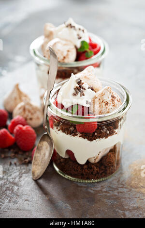 Layered dessert con torta al cioccolato e panna montata e lampone in un vaso Foto Stock