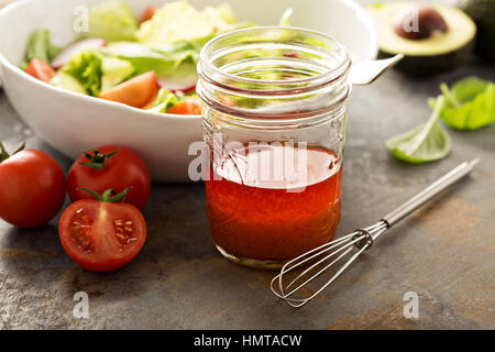 Pomodoro e olio di oliva condimento per insalata in un vaso Foto Stock