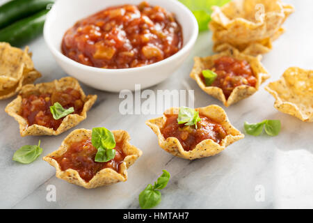 Di piccole dimensioni in stile messicano di antipasti con tortilla ciotole e salsa di pomodoro sulla scheda di marmo Foto Stock