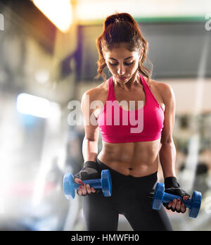 Donna muscolare è la formazione presso la palestra Foto Stock