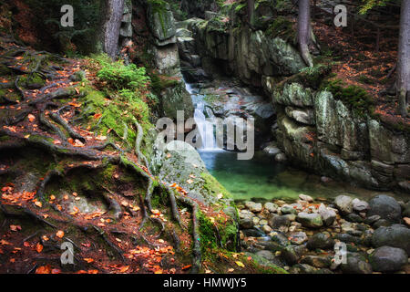 Luogo incantato dalla cascata in autunno di foreste di montagna dei monti Karkonosze, Sudetes, Polonia, Europa Foto Stock