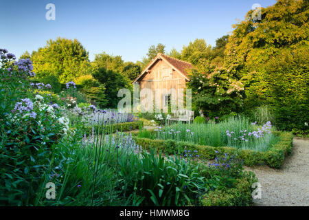 Jardins du pays d'Auge, qui giardino chiamato 'le repos du jardinier' con un fienile e 4 piazze di scatole e piante perenni Foto Stock