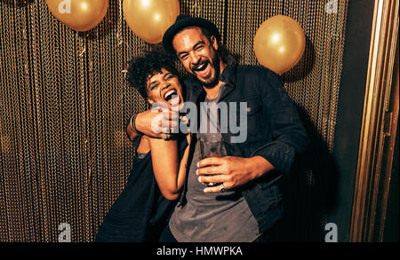 Immagine di felice coppia giovane divertendosi in discoteca. Giovane uomo e donna godendo di un partito. Foto Stock
