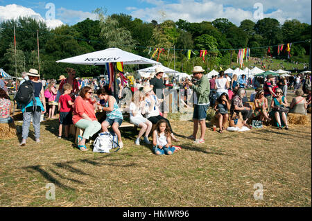 Famiglie godendo il cibo e le bevande su tavoli da picnic al porto Eliot Festival Cornovaglia Foto Stock