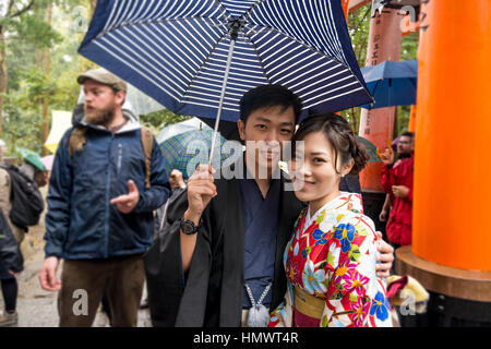 Giovane coppia orientali indossando il tradizionale costume giapponese kimono, Fushimi Inari Taisha (sacrario scintoista), Kyoto Foto Stock