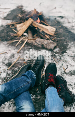 Ragazzo e ragazza piedi caldi nei pressi di un incendio Foto Stock