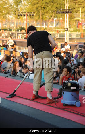 Un uomo hoovering un tappeto per la pista sul muoversi al ritmo Olympic Coca Cola Annuncio Foto Stock