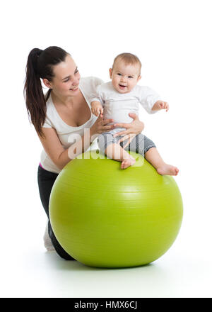 Giovane madre e il suo bambino neonato facendo esercizi yoga sulla palla ginnica isolato su bianco Foto Stock