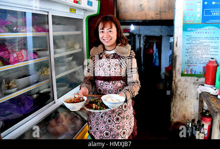 Huangshan, cinese della provincia di Anhui. 6 febbraio, 2017. Ningling Qing, un proprietario di un locale inn, si prepara per il pranzo dopo la ricezione di turisti sul Yuehua Street nel villaggio Qiyunshan sulla montagna Qiyun, est cinese della provincia di Anhui, 6 febbraio 2017. La strada si chiama 'heavenly street' come è stato costruito su una scogliera. Circa 30 famiglie vivono sulla strada e la maggior parte di essi si impegnano nell'industria del turismo. Credito: Tao Ming/Xinhua/Alamy Live News Foto Stock