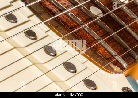 Primo piano di una chitarra elettrica USA Fender Stratocaster che mostra un pick-up a bobina singola, tasti in acciaio e parte del fingerboard in palissandro Foto Stock