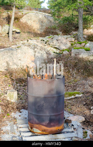 Incendio in un vecchio arrugginito barell in piedi nella natura Foto Stock