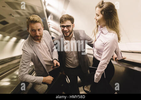 I suoi collaboratori utilizzando le scale della metropolitana insieme per ottenere la metropolitana Foto Stock