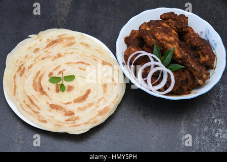 Il Kerala paratha / porotta / roti / parotta / barotta / Stratificato naan pane piatto maida farina di frumento a caldo con pollo al curry piccante Foto Stock