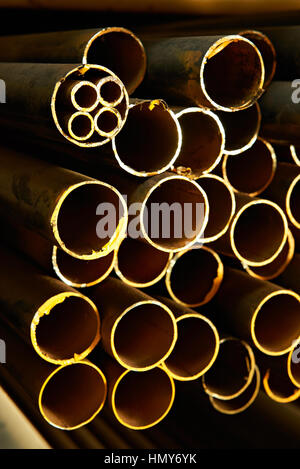 Rusty rotonda gialla dei tubi di acciaio in magazzino Foto Stock