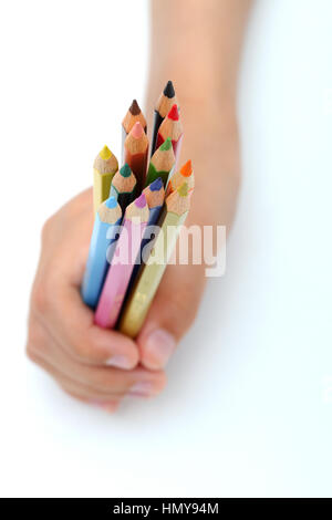 Stretta di mano destra presa matite di colore isolata contro uno sfondo bianco Foto Stock