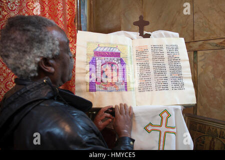 Gerusalemme, Israele - 8 dicembre 2013: monaco etiope con la vecchia Bibbia scritta in antica lingua Geez nel patriarcato etiope in Gerusalemme. Foto Stock