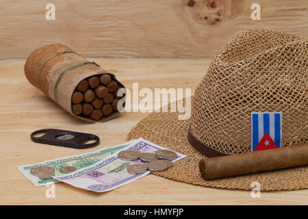 La Siesta - sigari, cappello di paglia e banconote cubano su un tavolo di legno Foto Stock