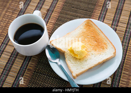 Servita tavolo per la prima colazione con pane tostato, caffè e di burro tablemat Foto Stock