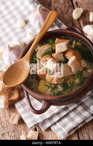 Zuppa di aglio con crostini di close-up in una ciotola sul tavolo. In verticale Foto Stock