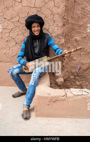 Il Marocco. Teenage Amazigh musicista berbero giocando un Gimbrie. Ait Benhaddou Ksar, un sito del Patrimonio Mondiale. Foto Stock