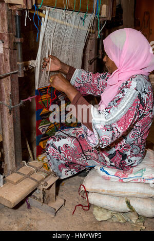 Il Marocco. Berber donna tessitura di un tappeto in casa sua. Ait Benhaddou Ksar, un sito del Patrimonio Mondiale. Foto Stock