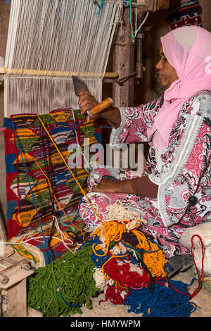 Il Marocco. Berber donna tessitura di un tappeto in casa sua. Ait Benhaddou Ksar, un sito del Patrimonio Mondiale. Foto Stock