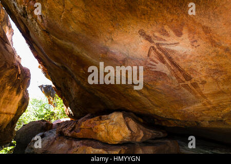 Antica aborigena Gwion Gwion pitture rupestri anche sapere come Bradshaw arte rock dotato di mascherine per stencil a mano e una figura umana Foto Stock