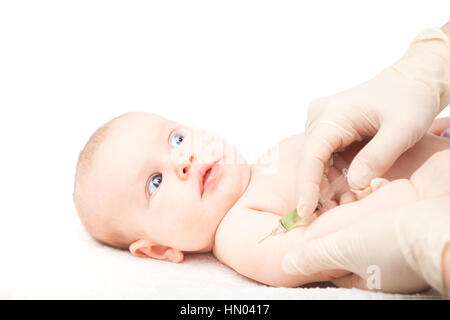 Pediatra dando a tre mesi di baby girl iniezione intramuscolare in braccio. Bambino cerca ansiosamente presso un medico Foto Stock