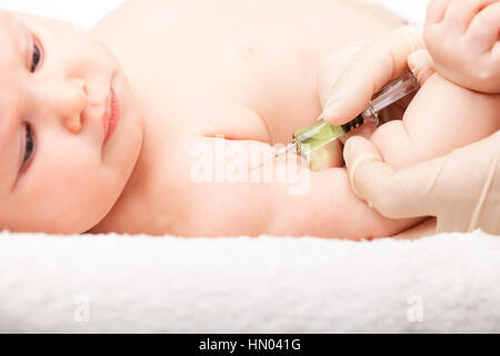 Close-up shot di pediatra dando a tre mesi di baby girl iniezione intramuscolare in braccio Foto Stock