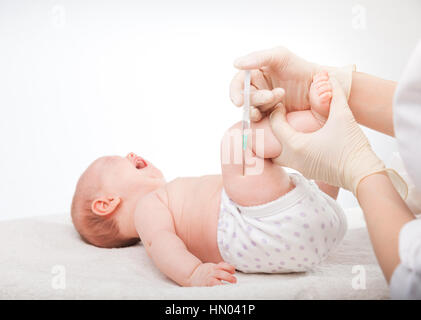 Close-up shot di pediatra dando a tre mesi di baby girl iniezione intramuscolare in gamba Foto Stock