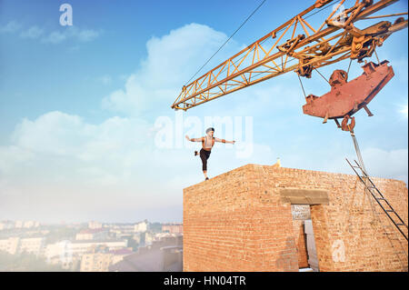 Athletic uomo fare esercizio sulla parete alta. Foto Stock