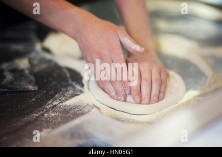 Mani impastare la pasta per pizza rendendo Foto Stock