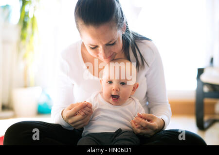 Bella madre mentre tiene il suo grazioso baby figlio Foto Stock