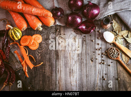 Fresche verdure crude e spezie su grigio superficie in legno, spazio vuoto nel mezzo, tonificazione vintage Foto Stock