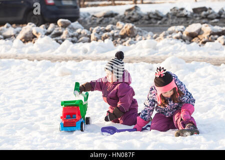 I bambini giocano sulla neve Foto Stock