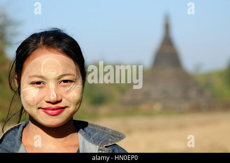 MRAUK-U, MYANMAR - gennaio 24: Ritratto di donna birmana nel make-up tradizionale fatta di Murrays polvere di legno in background i templi buddisti Foto Stock