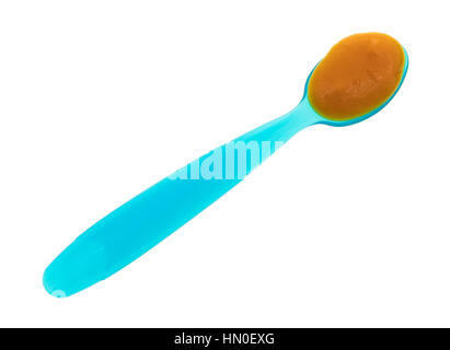 Vista dall'alto di una cucchiaiata di banana carota e mango alimenti per neonati su un cucchiaio di blu isolato su uno sfondo bianco. Foto Stock